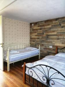 梅斯蒂亚萨克利拉哈姆什旅馆的一间卧室设有两张床和木墙