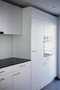 吉斯维尔Sandras Flat的厨房配有白色橱柜和黑色台面