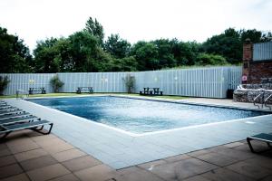 布莱克浦布莱克浦乡村酒店的一个带长椅和围栏的游泳池
