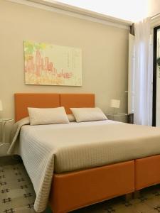 卡塔尼亚桑久利安诺114住宿加早餐酒店的一间卧室配有一张带橙色床头板的大床