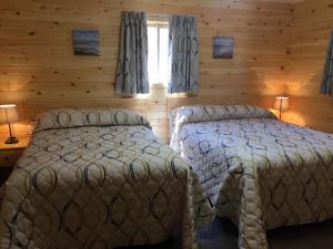 卡文迪西卡文迪什梅普尔斯别墅酒店的小木屋内一间卧室,配有两张床