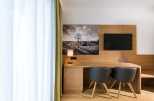 菲拉赫加尼索莱尔酒店的客房设有一张桌子、两把椅子和一台电视