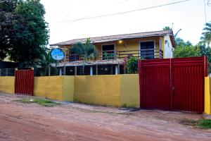 因巴塞Pousada Pelô de Imbassaí的房屋前有红色门的栅栏