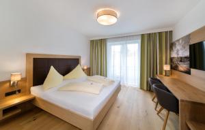 菲拉赫加尼索莱尔酒店的酒店客房设有一张大床和一张书桌。