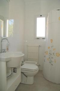 皮纳马尔Complejo Tridente的白色的浴室设有卫生间和水槽。