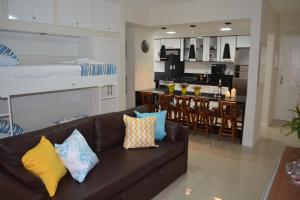 马塞约Sun Paradise - Pio X的一间带棕色沙发的客厅和一间厨房