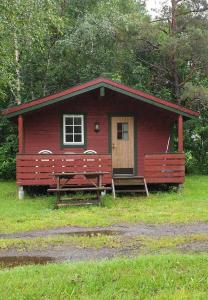 IsfjordenRomsdalseggen Camping的前面有两长椅的红色小屋