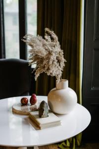 金斯顿罗斯蒙特宾馆的桌子上白色的花瓶,上面有书籍和苹果