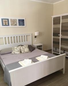 兰佩杜萨Camere a Sud - Lampedusa的卧室配有一张带两个枕头的大白色床