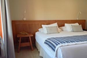 圣佩德罗·德·阿塔卡马卡萨唐托马斯酒店的一间卧室配有一张床和一个木制床头板
