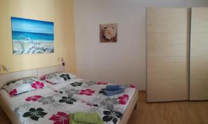 科佩尔Apartment Možina的卧室配有一张床,墙上挂有绘画作品