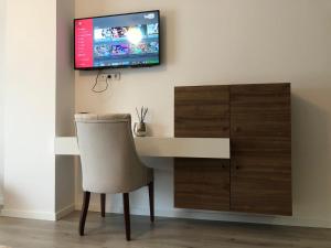 米特罗维察Hotel Dardani的一张桌子、椅子和墙上的电视