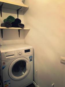 札勒乌Lux Apartament的洗衣房配有洗衣机和书架