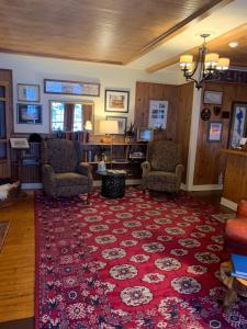 East MiddleburyWaybury Inn的一间客厅,配有红色地毯和两把椅子