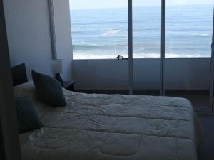 伊基克Boulevard del Mar Iquique ,Tierra de Campiones的一间卧室配有一张床,享有海景