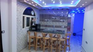 马特鲁港Al-Madina Tower Apartments的厨房设有带木凳的酒吧