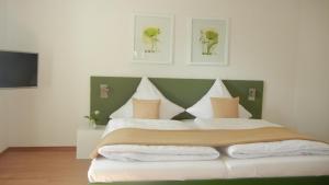 瓦门施泰纳赫芭芭拉旅馆的一间卧室配有一张大床和绿色床头板