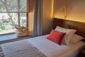 圣佩德罗·德·阿塔卡马卡萨唐托马斯酒店的靠窗的红色枕头床