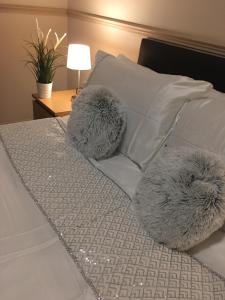 阿伯丁Terra Nova Hotel的一张带白色枕头和两个模糊枕头的床