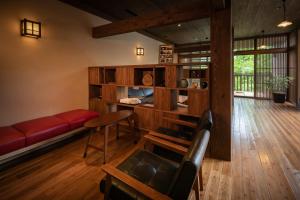 南小国町Ryokan Nanjoen的客厅配有红色的沙发和桌子