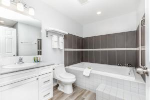 奥索尤斯Westridge Motor Inn的白色的浴室设有浴缸、卫生间和水槽。