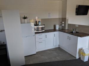 哈灵顿哈林顿村汽车旅馆的厨房配有白色冰箱和水槽