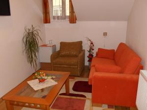 日利纳彭泽恩帕斯酒店的客厅配有橙色沙发和桌子