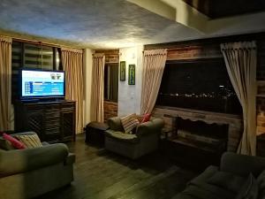 SutamarchánPosada San Esteban的客厅设有壁炉和电视。