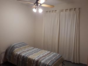 拉蓬塔Sierras de La Punta的一间卧室配有一张床和吊扇