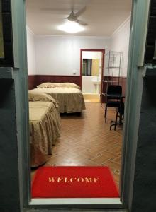 努库阿洛法The Village Backpackers的酒店客房,设有两张床和迎宾垫。