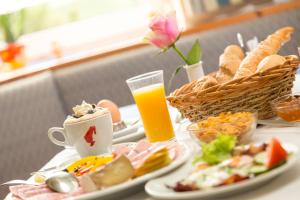 Oberegging托普莫特酒店的餐桌,盘子和一杯橙汁