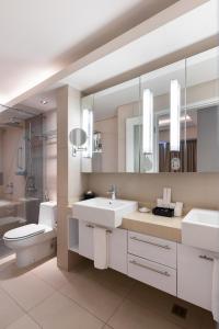 马尼拉Citadines Salcedo Makati的浴室设有2个水槽、卫生间和镜子。