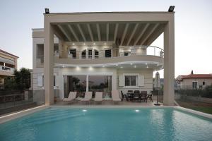 考瑙皮迪亚纳Cedar Tree Villa的一个带游泳池和阳台的别墅
