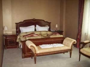 乌兰巴托Sunjin Grand Hotel的一间卧室配有一张大床和一把椅子