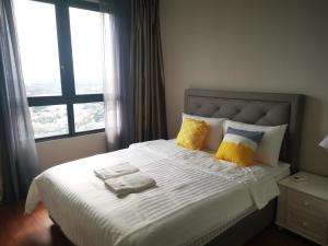 莎阿南Studio Apartment with Balcony by Host Assist i-City的一间卧室配有一张大床,提供黄色和蓝色的枕头