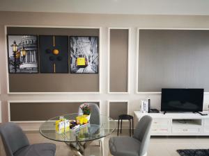 莎阿南Studio Apartment with Balcony by Host Assist i-City的客厅配有玻璃桌和椅子