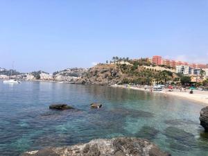 阿尔姆尼卡RESIDENCIAL PLAYA CABRIA的一片拥有岩石和水中人气的海滩