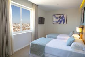 马德里Riu Plaza España的酒店客房设有两张床和窗户。