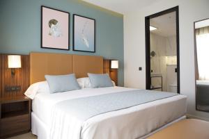 马德里Riu Plaza España的一间带白色大床的卧室和一间浴室