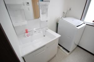 恩纳Akizero Onnason的白色的浴室设有水槽和镜子