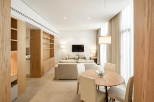 科威特Delta Hotel Apartments的客厅配有餐桌和沙发
