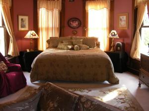 GolcondaRiverview Mansion Hotel的一间卧室设有一张大床和两个窗户。