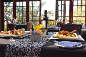 比勒陀利亚瀑布精品酒店的一张桌子,上面放着两盘食物和酒杯