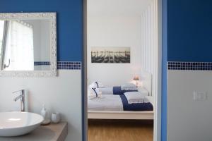 Piombino DeseLa Casa di Amedeo的浴室设有床、水槽和镜子
