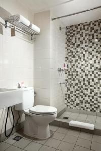 雅加达唐人街阿马里斯酒店的白色的浴室设有卫生间和淋浴。