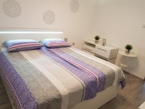 Krška VasApartments Stankovo的一间卧室配有一张带2个床头柜的大床