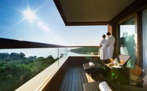 罗维尼Maistra Select All Suite Island Hotel Istra的一对夫妇站在建筑的阳台上