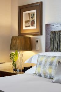 伦敦仕骅廷骑士桥酒店公寓的酒店客房配有一张床和一张带台灯的桌子