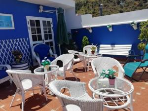 伊科德洛斯维诺斯德拉戈圣安东尼奥酒店的庭院设有白色的桌椅和蓝色的墙壁