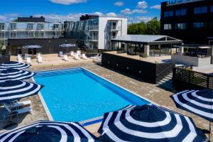 维斯比First Hotel Kokoloko的一个带蓝白遮阳伞的游泳池